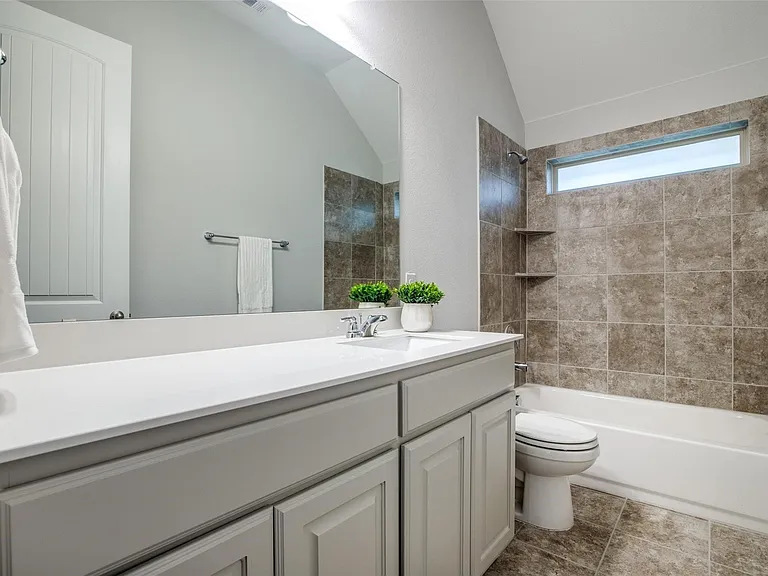 Bathroom featuring a light gray vanity with a single sink and white countertop