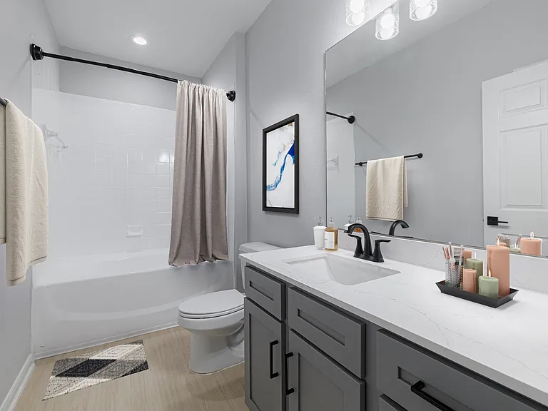 Renovated bathroom with granite countertops and modern cabinetry