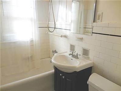 Hall bath with original wall tile and ceramic tile floor--newer vanity and toilet