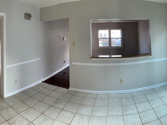 View from the kitchen to open concept living room, 1st bedroom and laundry room