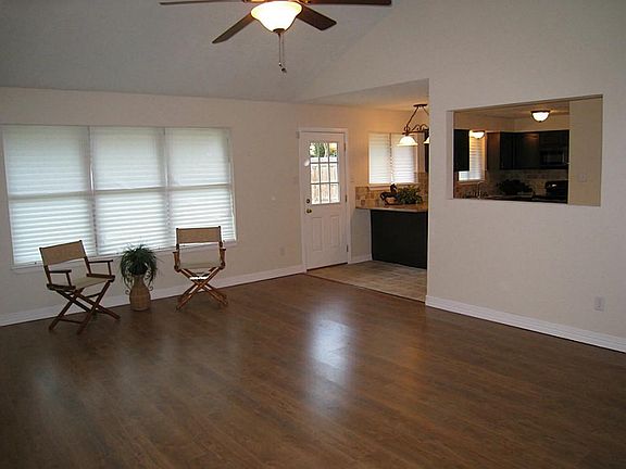 LIving room features Cathedral ceiling, laminate floors, fresh paint plus it's open to kitchen & dining