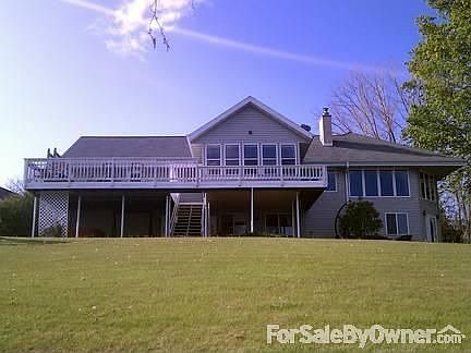View of rear of house from lake
						:
						Windows & 4 season room. 
Sprinkler system to keep your new lawn green.