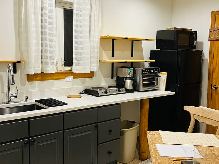 Efficiency kitchen with appliances, new countertop, sink, and new refrigerator.