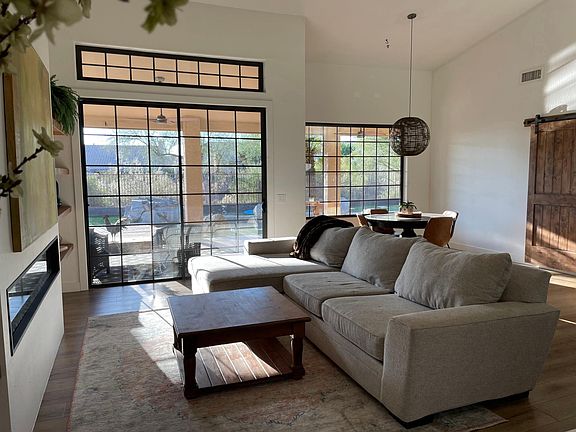 Living room with French door slider, linear electric fireplace and dining area.