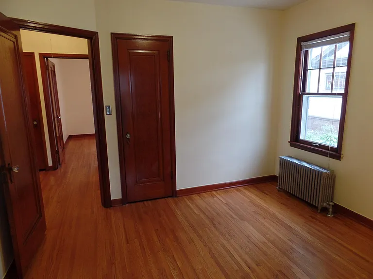Back Bedroom. Foyer with linen closet and door leading to front bedroom on the left. Closet in center.