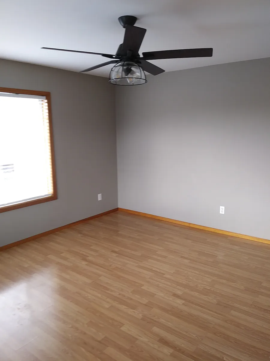 Living area, new laminate floors, new black ceiling fan, new paint - 725 Judson St #101