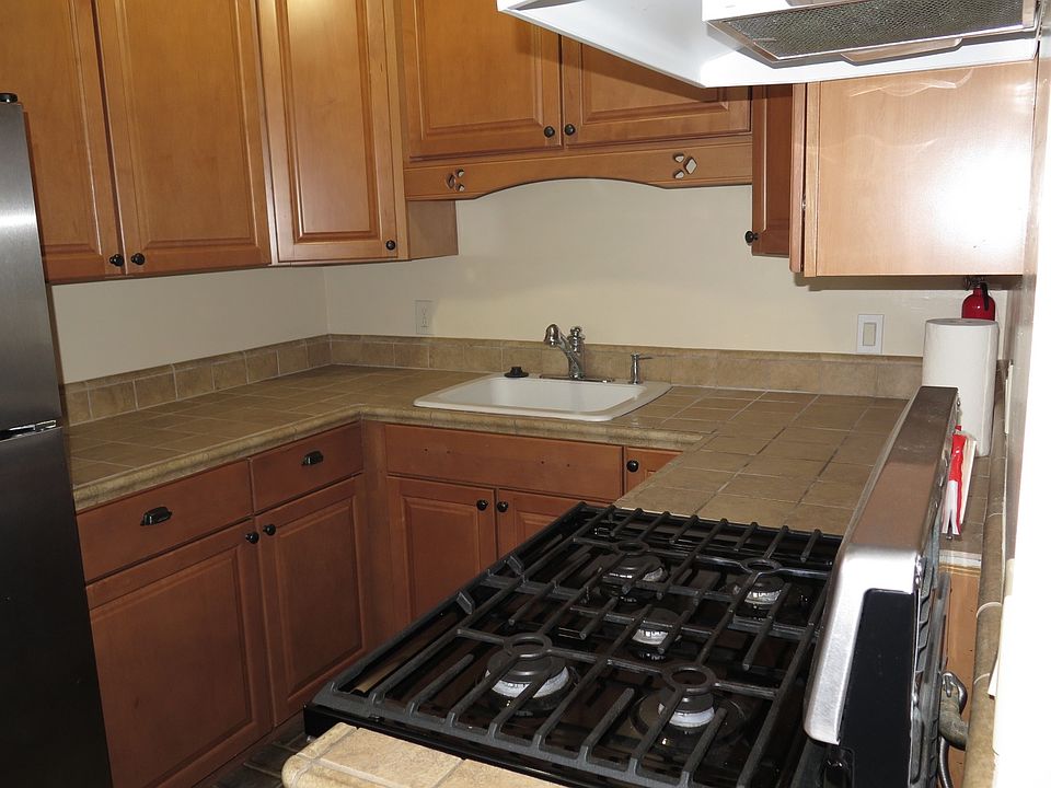 Beautiful kitchen with tile counters and gas stove