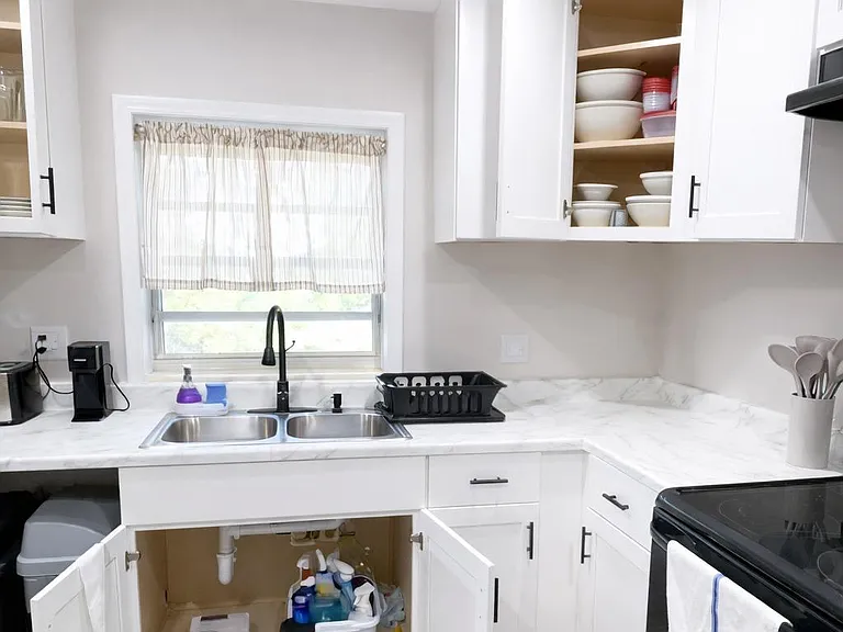 Updated kitchen with ample cabinetry, generous counter space, and a double-basin sink set under a window.