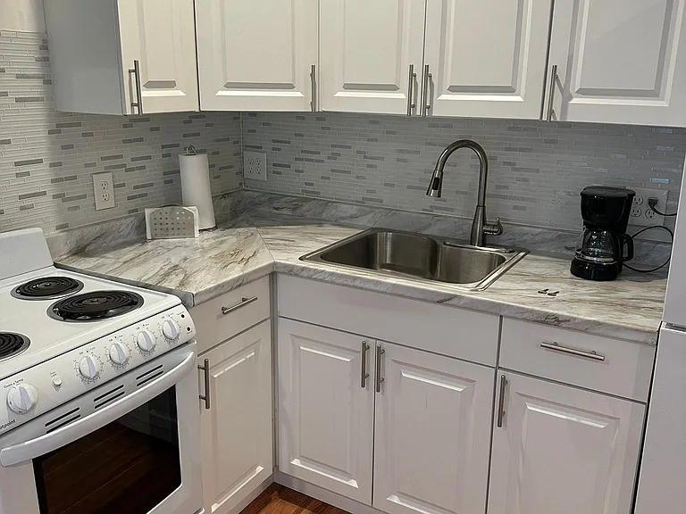 The kitchen is equipped with a refrigerator, coffee maker, and essential amenities.