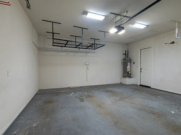 Spacious garage for secure off-street parking
Garage interior featuring overhead storage and home entry