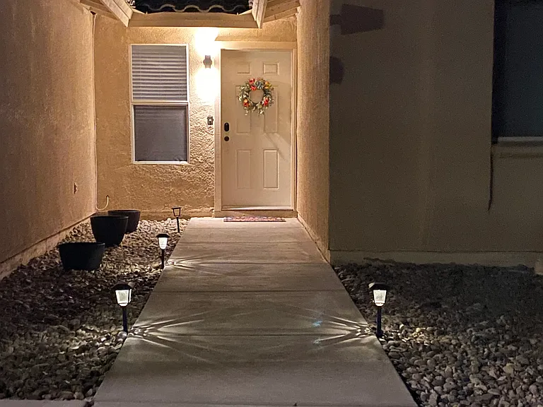 Bright and inviting exterior entry with illuminated path lights that guide you to the welcoming front door.