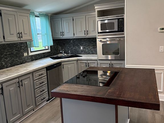 Kitchen: flat top cook stove with butcher island, new dishwasher, built in oven and microwave, window overlooking lake