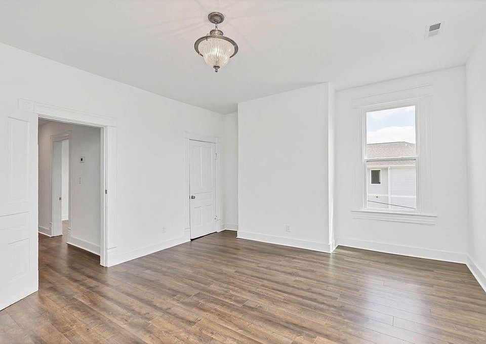 Living room with tall cielings, closet, and large windows overlooking McCallie Ave.