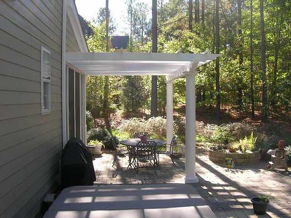 The pergola adorns the stone patio