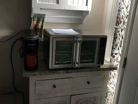 Kitchenette area with Refrigerator, micro wave, coffee maker, and air fryer.