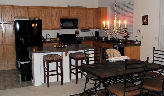 Kitchen w/ Corian and blakc appliance, blk cast iron sink