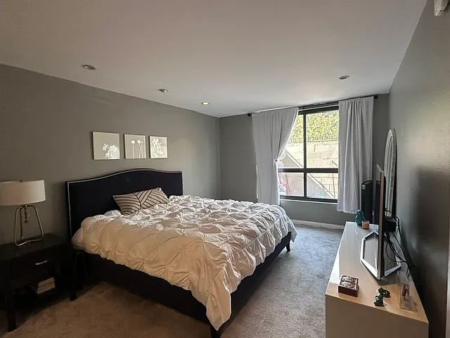 Master bedroom with large window and recessed lighting. Dimensions: 15ft x 15ft