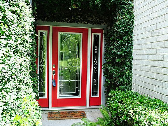 Check out the unique beveled glass front door and the lush landscape.