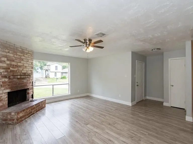 Inviting living room with big windows and ceiling fan