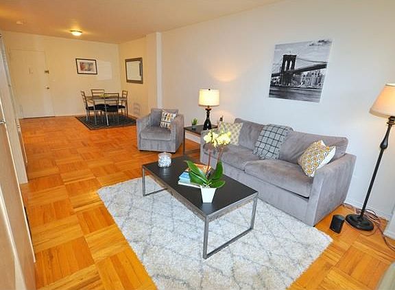 Bright living room has a door leading to a balcony that is great for enjoying the outdoors.  The living room opens to the dining foyer and has parquet floors.  The room is 30'-2" by 12'-4".