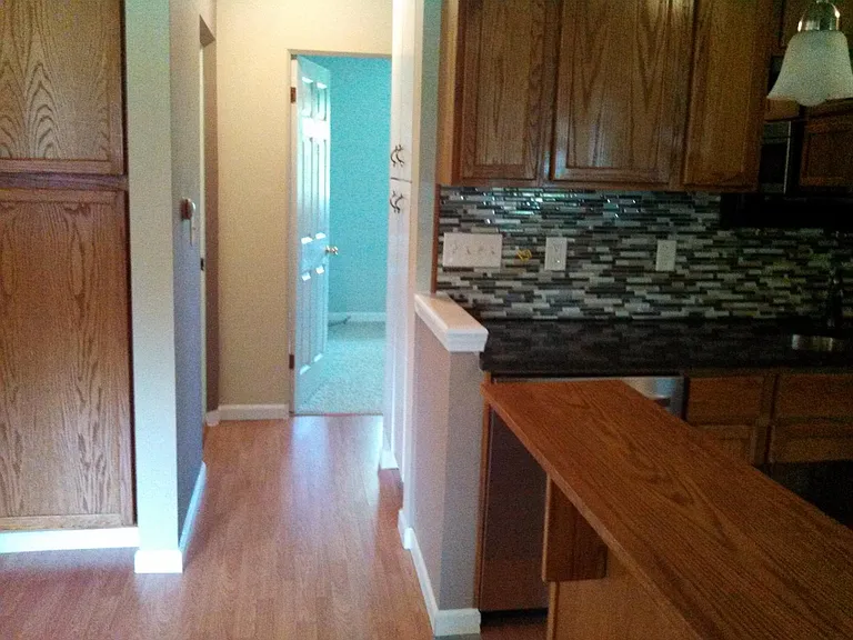 Upstairs hall adjacent kitchen leading to upstairs bathroom and two bedrooms.