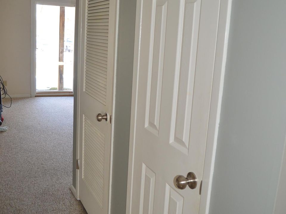 Front entry looking down hallway toward the living room. Smaller bedroom on the left. Hallway closet and utility closet to the right as seen in the photo.