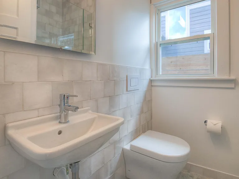 Guest bathroom off hallway past dining room on left.
