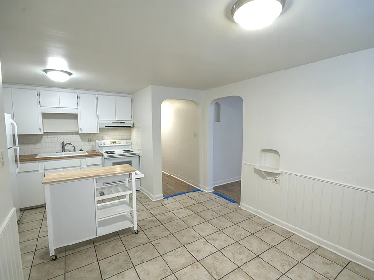 Kitchen, looking at doorway to living room, and hallways to bedrooms