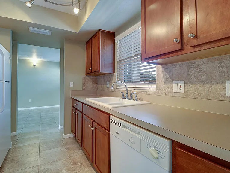 Kitchen has stone tile backsplash and a closet pantry plus additional storage closet