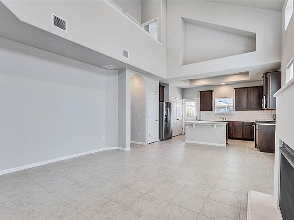Living room has ceilings open to the 2nd level and a gas fireplace.