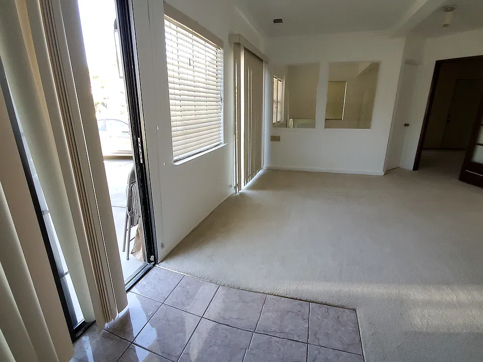 Main Entry sliding glass door & front unit window, eqquipped with vertical blinds for privacy.