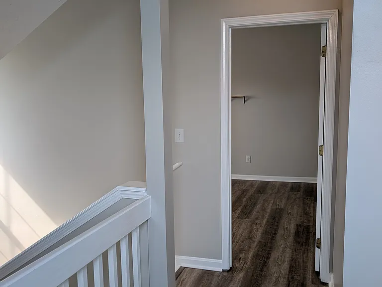 Upper landing area connecting the staircase, loft, and bedroom access