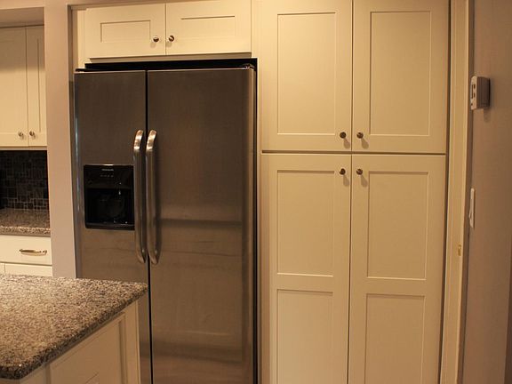 Full pantry next to refrigerator