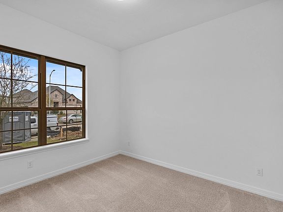 With two windows overlooking the front of the home, this secondary bedroom offers a light-filled spa