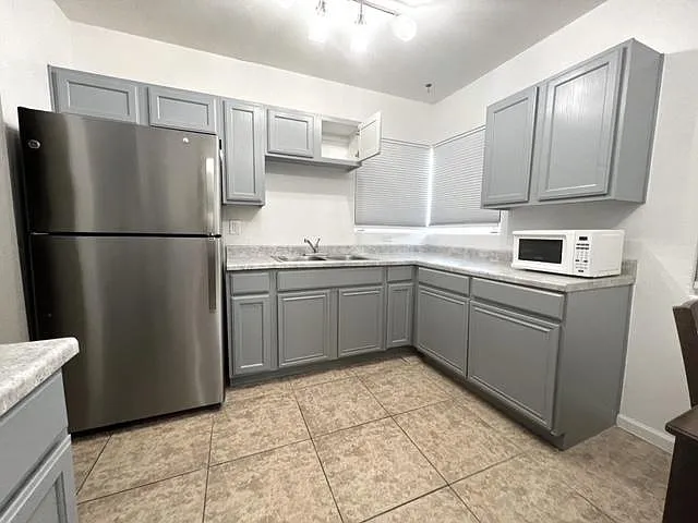 Freshly painted cabinets and new counters, modern lighting, new refrigerator.