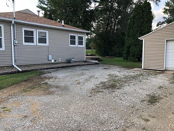 East side view of 120 Carrington. Backdoor (not in view) and deck are to right and front door is not in view to left. Partial garage view.