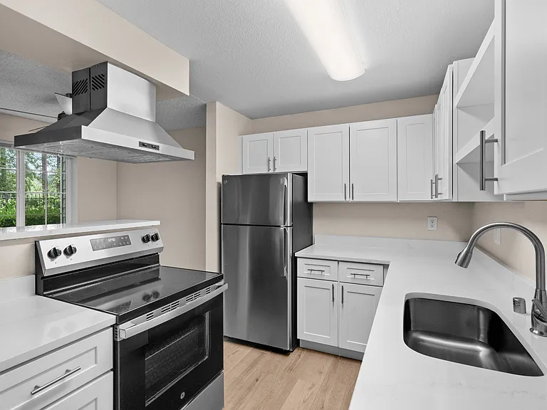 A bright, updated apartment kitchen featuring generous cabinet storage, sleek countertops, and stainless steel appliances. A bright, updated apartment kitchen featuring generous cabinet storage, sleek countertops, and stainless steel appliances.