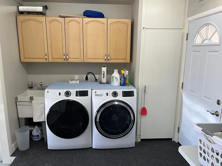 GE washer and dryer in raised "extension" on front of garage. This (like the adjoining patio) is covered with outdoor carpeting.