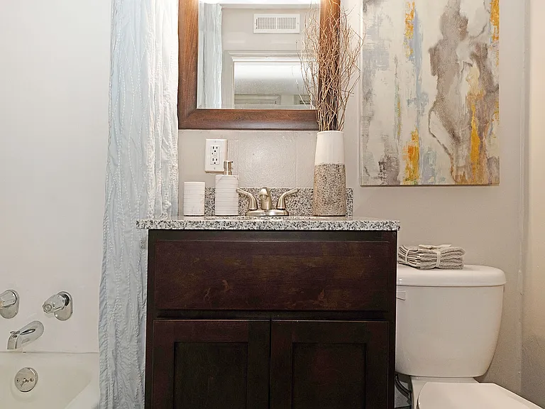Bright bathroom with granite counters and bathtub