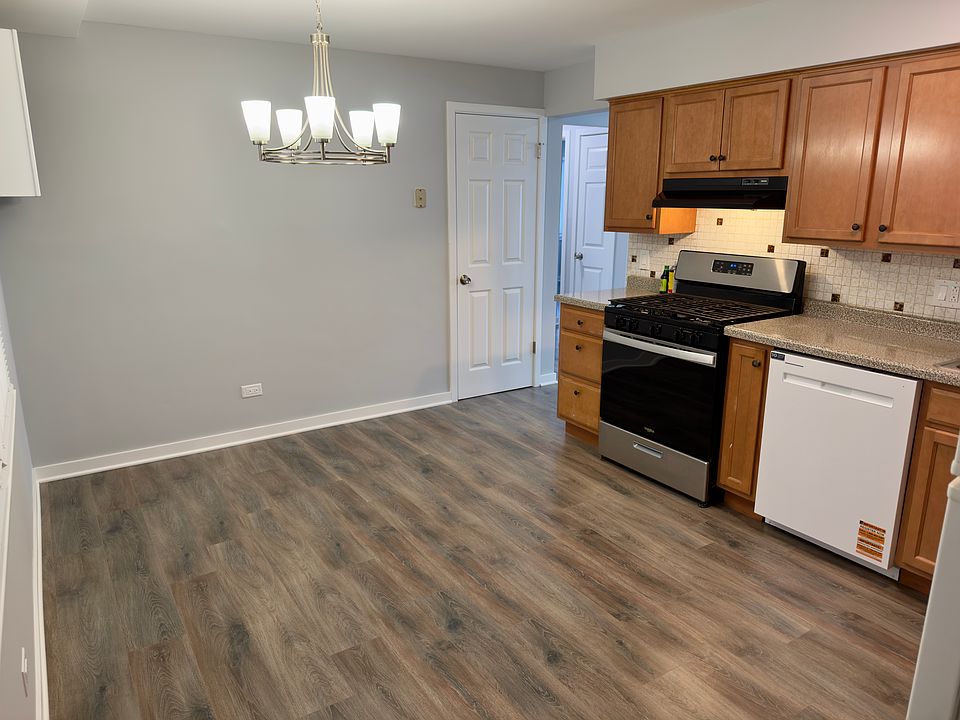 Spacious kitchen with modern vinyl plank flooring, ample cabinet storage, gas range, new dishwasher, full-size fridge.