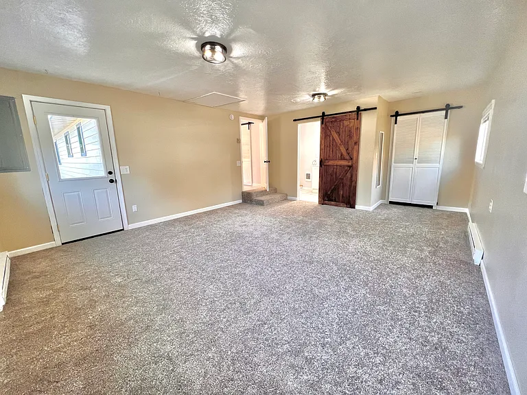 Master bedroom, barn door to full bath, and bifold bard door to "his" closet