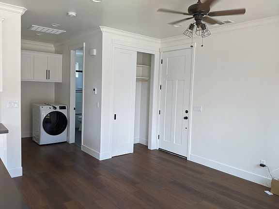 carport door, entryway coat closet and laundry with upper linen cabinet