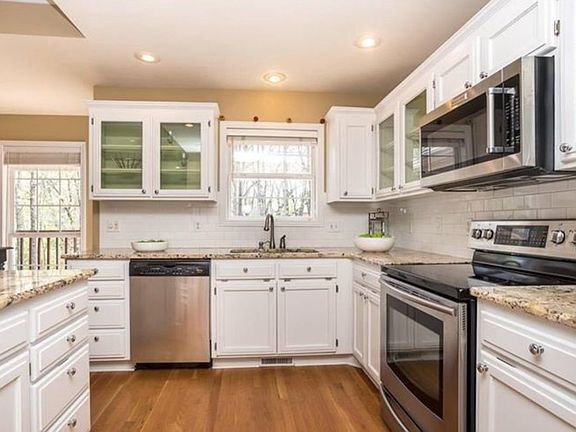 Induction range, sink overlooks beautiful backyard (if dishes must be done, best to do them with a view!), and ample storage