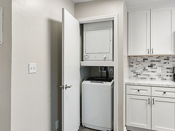 Embrace convenience with this chic kitchen design featuring a built-in laundry nook.