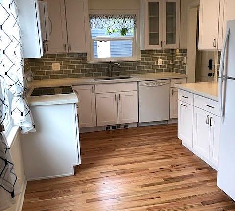 Light and bright, with tile backsplash, undercounter lighting, and dedicated eating space.