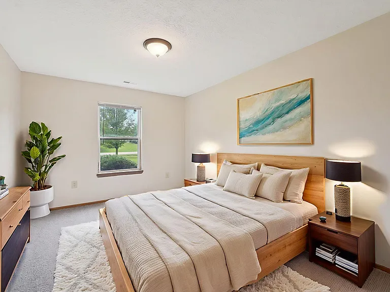 Dooley's Orchard apartment showing a bedroom layout with a large bed and a painting on the wall.
