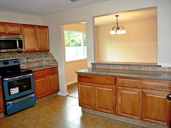 Another view of kitchen with tile floors and new light fixtures and hardware