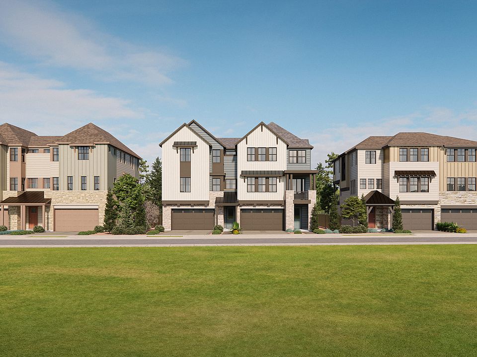 A row of modern, multi-story townhouses with tiled roofs and garages in the foreground, set against