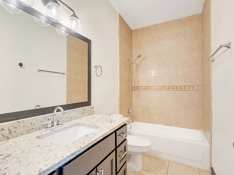 Bathroom view from Merida Vista Apartments in Laredo, Texas, with a tub, sink, and wall-mounted mirror