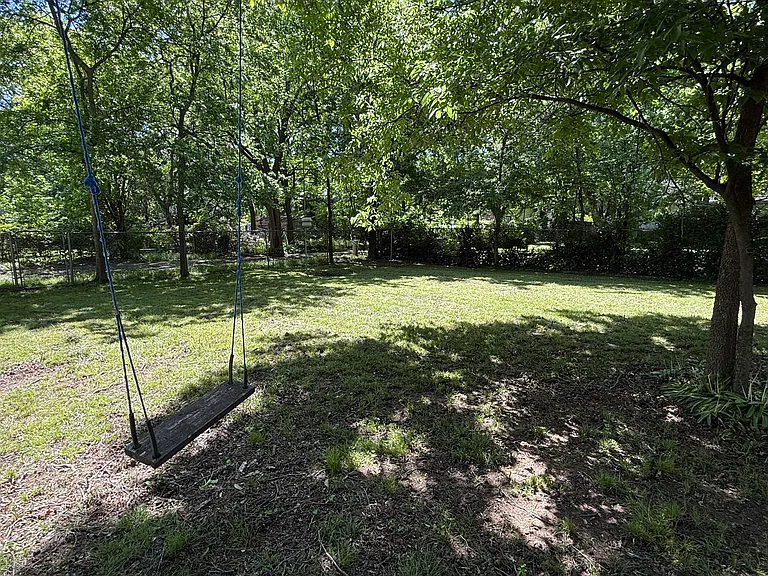 Large fully fenced yard with shade trees